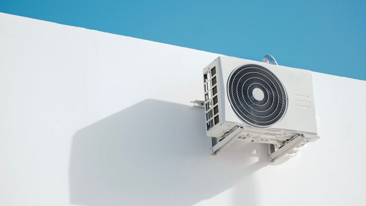 3 zone DIY mini split outdoor condenser mounted on a white exterior wall, the single outdoor unit that serves three indoor zones