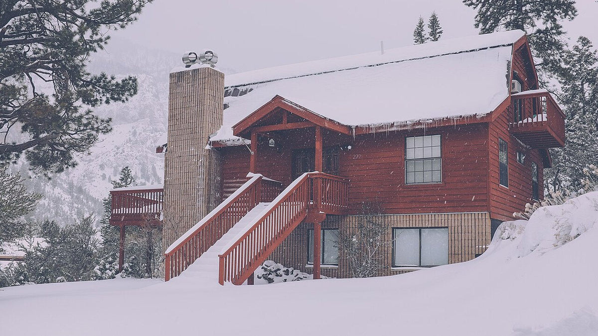 Snow-covered cabin in the mountains, the kind of cold climate a DIY mini split heat pump has to heat through winter