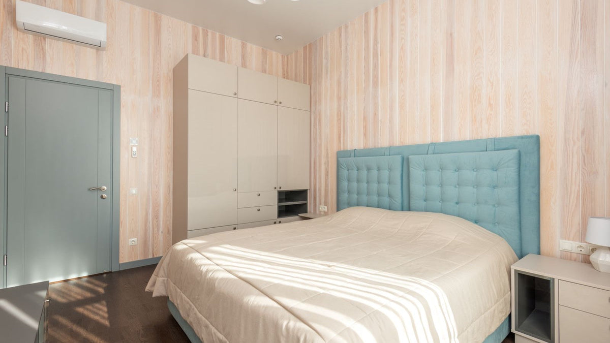 White wall-mounted 12,000 BTU mini split indoor unit in a bedroom, the room size a 115V DIY mini split like Zone Air or MRCOOL DIY is built for