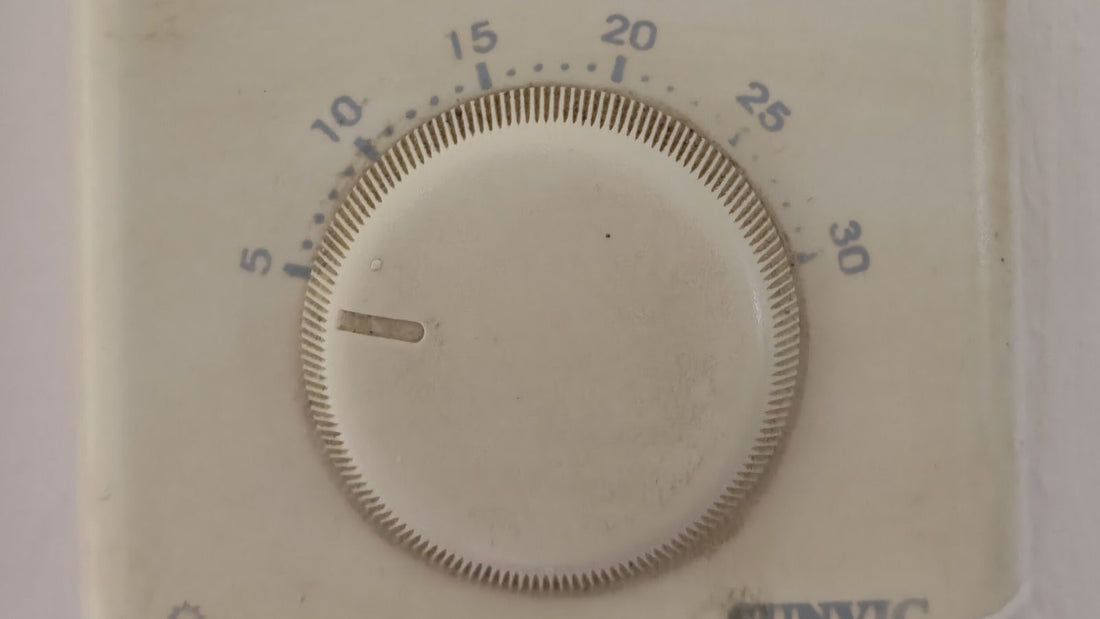 Wall-mounted Sunvic electronic thermostat with circular temperature dial showing 5 to 30 degrees Celsius, replace a thermostat guide example